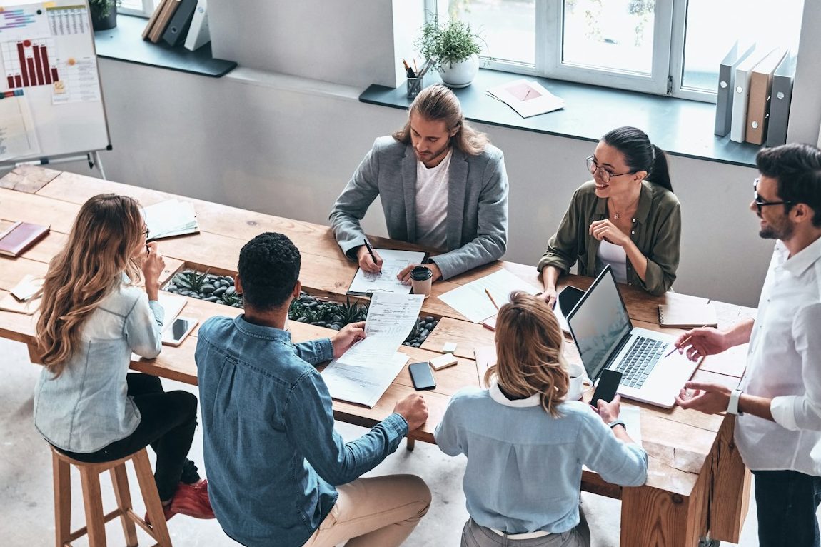 Team im gemeinsamen Austausch über gesunde Zusammenarbeit, Klarheit und bewusste Selbstführung im Arbeitsalltag.
